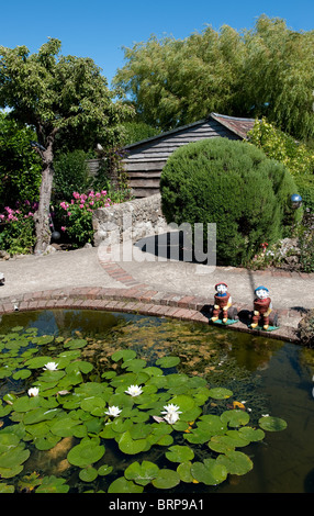 Ornaments at the side of a pond in the pretty village of Godshill in the Isle of Wight, England. Stock Photo