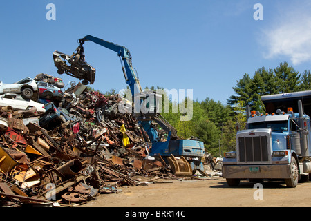 Crane loading semi truck with crushed cars, scrap metal automobiles, at ...