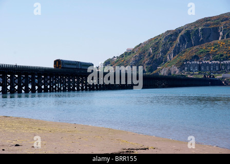 A Train crosses the  Barmouth Railway Bridge over the  Mawddach Estuary Stock Photo