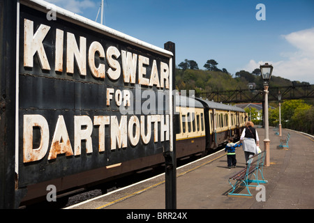 UK, England, Devon, Kingswear station platform, steam train passengers walking past Dartmouth sign Stock Photo