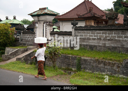 Indonesian woman in Bali carrying water on her head Stock Photo