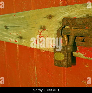 A rusty lock on a red wooden door Stock Photo