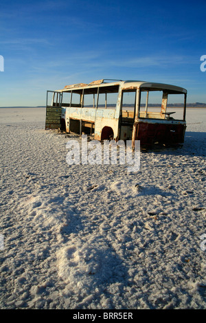 A broken and rusted bus wreck lies on the salt lake of Chott el-Jerrid in the south of Tunisia Stock Photo