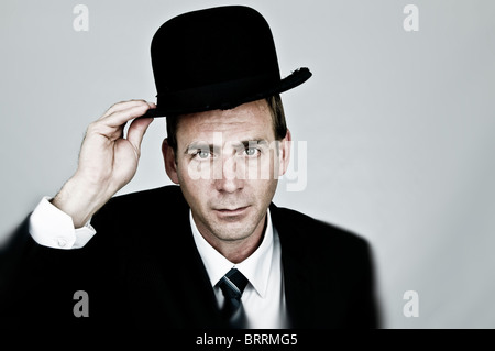 man with suit and bowler hat holding placard with, the end of rent is ...