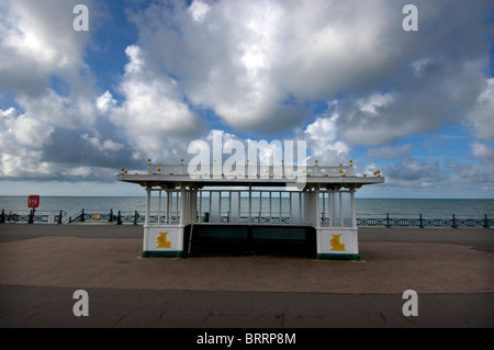 A 1860s beach shelter on the seafront at Kings Esplanade on Hove promenade with puffy cumulus clouds above. Stock Photo