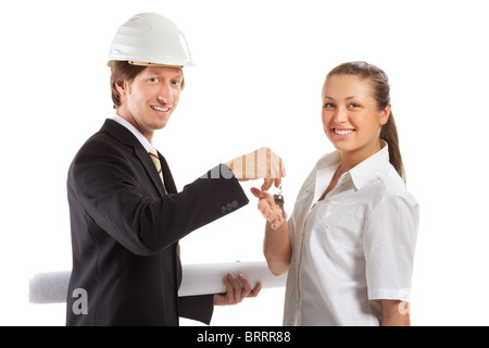An architect wearing a hard hat and co-worker reviewing blueprints Stock Photo
