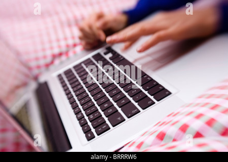 Child using laptop on bed Stock Photo