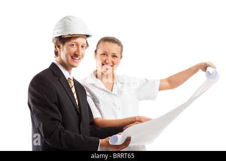 An architect wearing a hard hat and co-worker reviewing blueprints Stock Photo