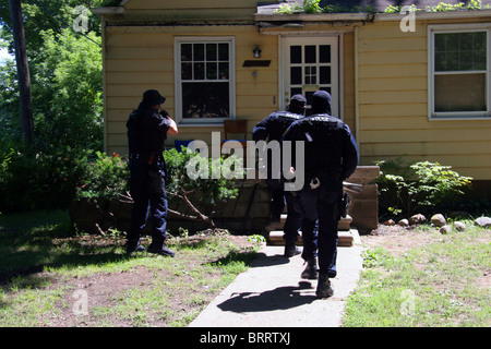 Detroit police narcotics officers rush from their van to raid a house ...