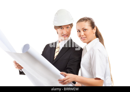 An architect wearing a hard hat and co-worker reviewing blueprints Stock Photo