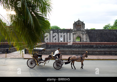 A horse and buggy pass the main gate of Fort Santiago in the historic Intramuros section of Manila, Philippines. Stock Photo