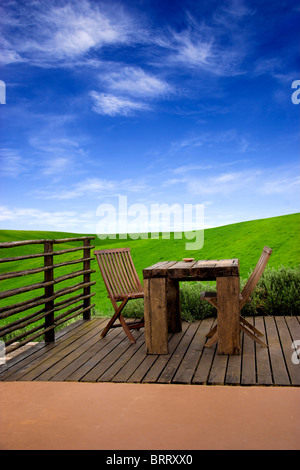 Beautiful outdoor space with a table and chairs and in the background a beautiful green meadow Stock Photo
