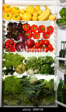 Refrigerator filled with many different vegetables, fruits, salads. Stock Photo