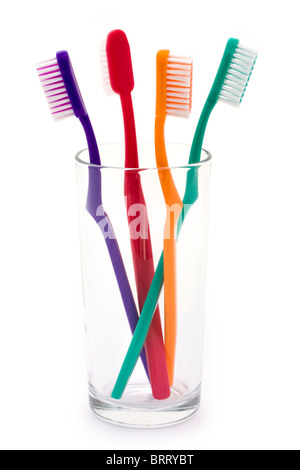 colourful toothbrushes in a glass over white Stock Photo