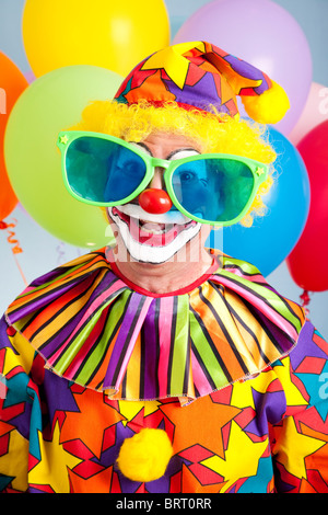 Funny birthday clown wearing over-sized novelty sunglasses.  Stock Photo