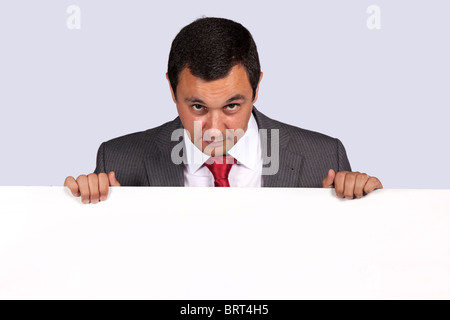 Businessman holding a blank billboard and looking to the camera Stock Photo