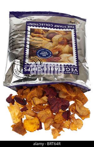 Opened packet of sweet potato and beetroot fried vegetable chips spilling onto a white surface Stock Photo