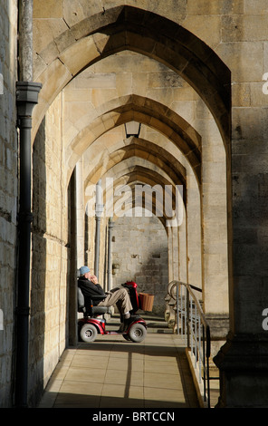 Disability users ramp for access and entrance into Winchester Cathedral Man resting in the sunlight on a mobility scooter Stock Photo