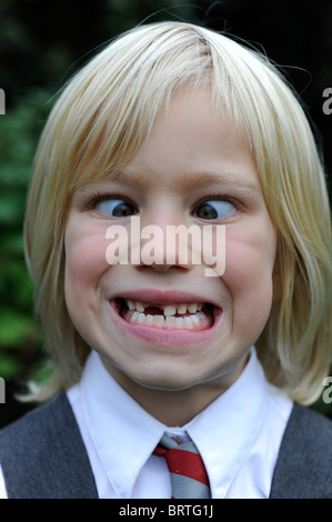 6 year old school girl pulling a silly face with a missing front tooth Stock Photo