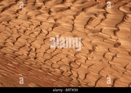 reddish sand and mud ripples caused by flowing water Stock Photo