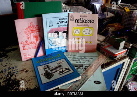 The official Lao government primary school textbooks and workbooks rest on a table at a store in Luang Prabang, Laos. Stock Photo