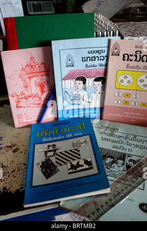 The official Lao government primary school textbooks and workbooks rest on a table at a store in Luang Prabang, Laos. Stock Photo