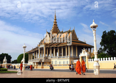 Buddhist monks are walking along the street fronting the grounds of The Royal Palace Temple Museum in Phnom Penh, Cambodia. Stock Photo