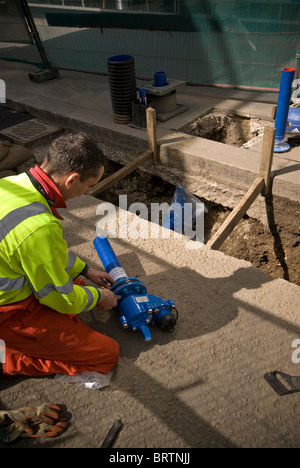 Water engineer replacing pipes in the City of London, UK Stock Photo