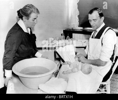 A man practices baby care, historical image, ca. 1928 Stock Photo