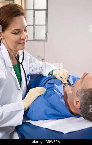Female doctor using a stethoscope for auscultating a patient Stock Photo