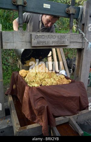Using an apple press to crush apples to make juice at a community apple day at Parke, Dartmoor National Park Devon Stock Photo