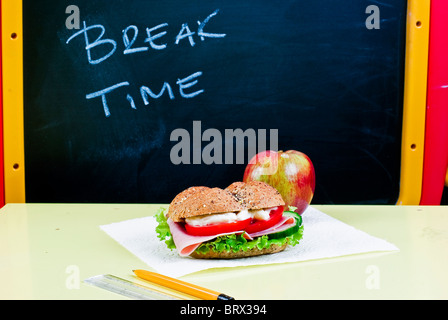 Sandwich and apple on classroom table - breakfast Stock Photo