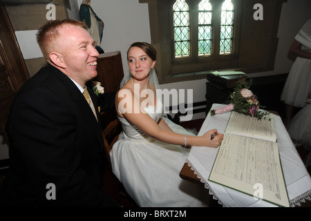 Bride and groom just married signing the register Stock Photo