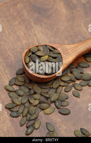 Close up of toasted pumpkin seeds in wooden spoon Stock Photo