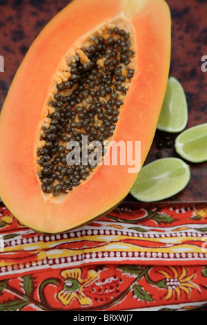 Close up of split papaya and limes Stock Photo