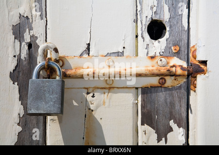 Padlock and rusty bolt on an old wooden door Stock Photo