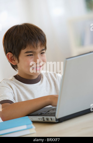 Smiling mixed race boy using laptop Stock Photo