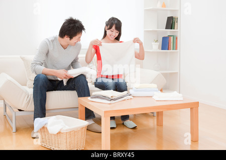 Couple folding laundry, Japan Stock Photo
