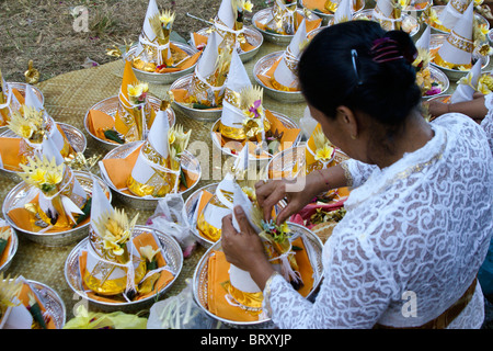 Woman preparing offerings at cremation ceremony, Bali, Indonesia Stock Photo