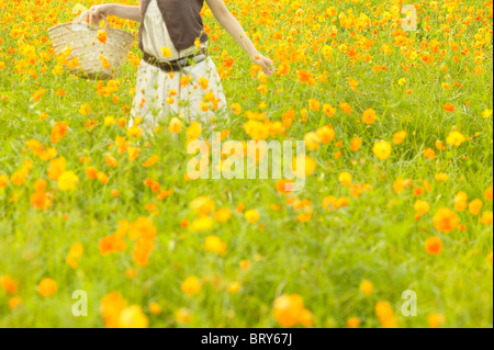Young woman standing in flower field Stock Photo