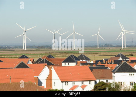 Wind turbines behind housing estate Camber Rye east Sussex Stock Photo