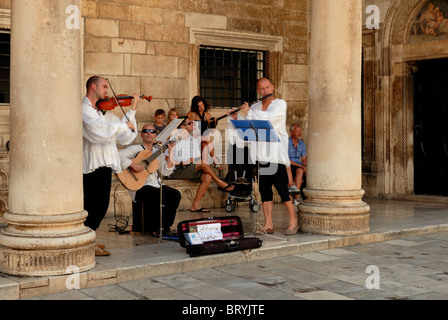 Three men in traditional costumes playing music in the portico of Rector's Palace. The Rector's Palace is often used for concert Stock Photo