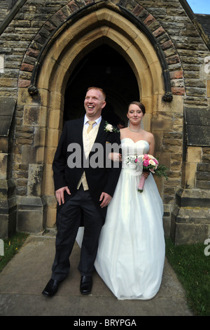 Bride and groom just married walking out the church Stock Photo