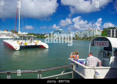 Tourist couple on ferry boat in Castries waterfront harbor Saint Lucia with woman taking a picture of the scene Stock Photo