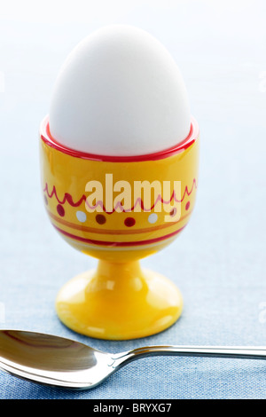 Closeup of soft boiled egg in cup with spoon Stock Photo