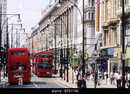 Oxford Street, Red Busses, Selfridges London West End bus shops shoppers shopping streets English England UK Stock Photo