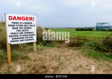 Sign warning of danger from flying golf balls at Brancaster Golf Course, Norfolk, England Stock Photo