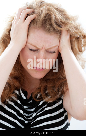 stressed woman with hands on temples Stock Photo