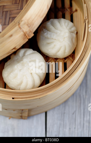 Close up of steamed dim sum pork buns in bamboo basket Stock Photo