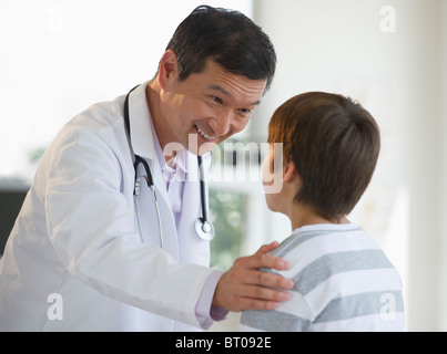 Smiling doctor touching boy's shoulder Stock Photo